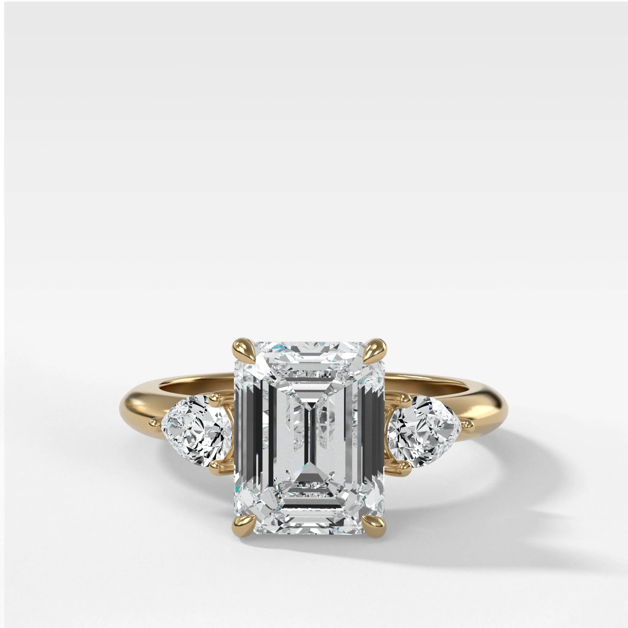 Three Stone Engagement Ring With Pear Side Stones and Emerald Cut Diamond